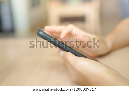Woman hand using smartphone with cafe shop colorful beautiful bokeh background. Business, financial, trade stock maket and social network concept.