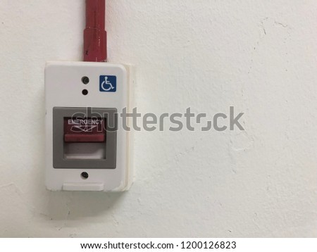 Red fire alarm emergency switch on white concrete wall