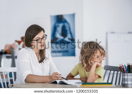 A bored child refusing to cooperate with his private teacher while doing homework. Royalty-Free Stock Photo #1200155335