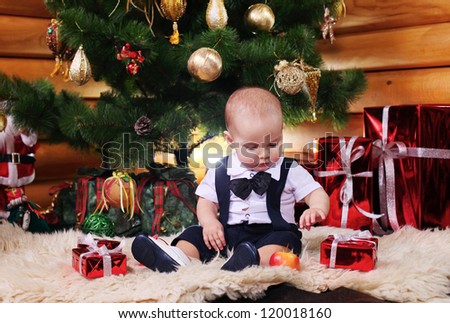 	Cute baby boy with Christmas gifts