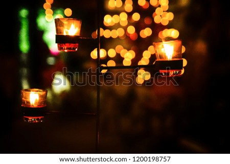 Candles in temple or candle in glass jar. Celebration light with complete black and blurred background. Selective focus
