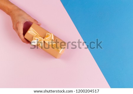 Woman holding gift box on color background