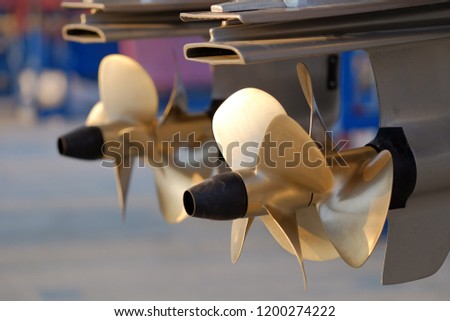 Shallow DOF close-up of the boat's double brass propellers. Royalty-Free Stock Photo #1200274222