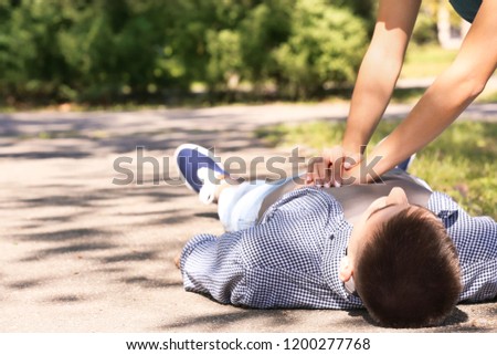 Passerby performing CPR on unconscious man outdoors. First aid Royalty-Free Stock Photo #1200277768
