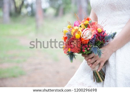 bride's hands with a bouquet of colorful flowers