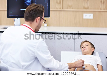 Picture of male doctor testing young boy with usg
