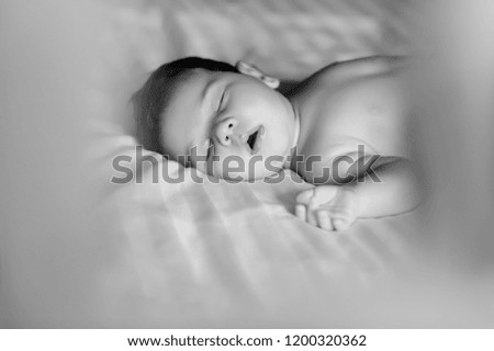 black and white picture of cute little baby boy sleeping in bed at home