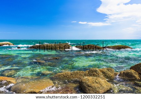 Beautiful stony coast of the South China Sea against the blue sky with a cloud in Vietnam