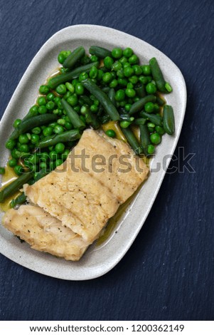 cod fish with green beans and peas on dish
