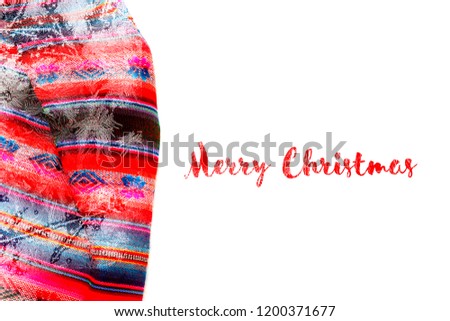 Festive Christmas holiday winter background with bright multicolor tablecloth in traditional colors covered sparkling snowflakes on white backdrop. Inscription Merry Christmas