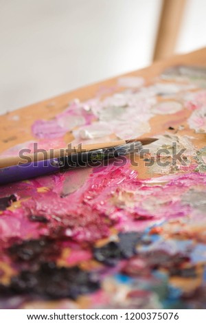 artists brushes and oil paints on wooden palette