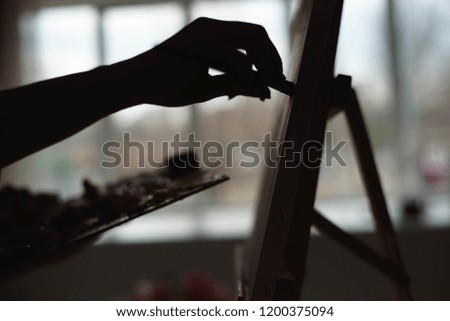 Girl painting in front of the window