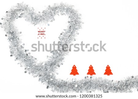 Christmas silver grey garland decoration photo as a heart for love emtion with a Merry Christmas label and red paper trees on white background.