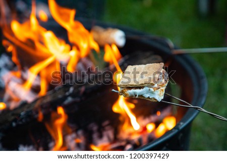 Cooking s’mores on a cool summer night in the mountains of northern Idaho Royalty-Free Stock Photo #1200397429