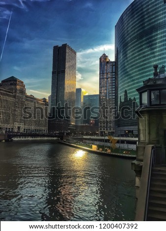 Sunlight reflects onto the Chicago River on warm autumn morning during rush hour.