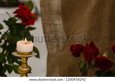 Romantic composition with candle and red roses. whtite and black background