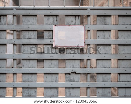 Blank white board hang on entrance gate. Empty text on attention board. Old vintage wooden fence with no people at abandoned house.