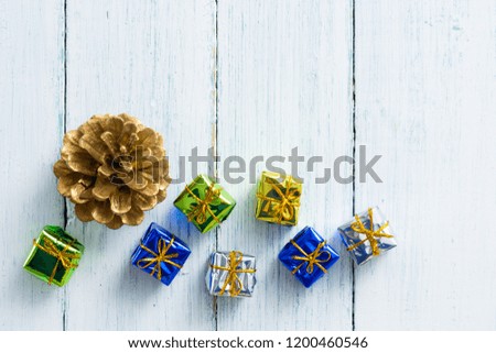 gold painted pine cone and gift box on white wood