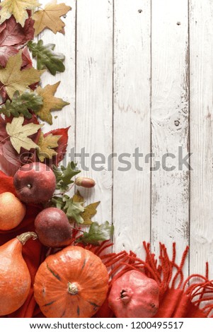 Autumn composition of dry leaves and pumpkins, on a white wooden table. Top view.