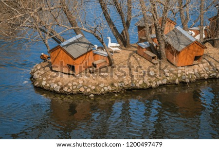 Image of wooden houses for mandarin ducks on the pond