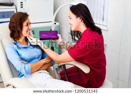 The patient is consulted by a beautician. Doctor advises the drug to the patient, holds a box of medicine Royalty-Free Stock Photo #1200531145