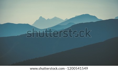 western carpathian mountain tops in  autumn covered in mist or clouds with blue cast and multidimensional lines - vintage retro look