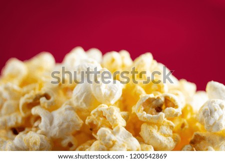 Popcorn Looks delicious in a paper red and white line  cup on a red scene 