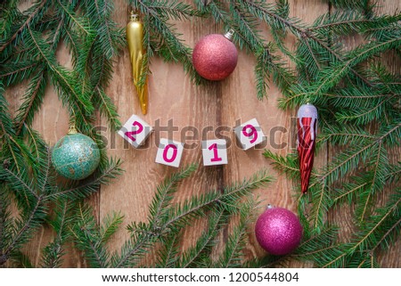 New year 2019 - number on cubes with Christmas tree branches and toys on wooden background