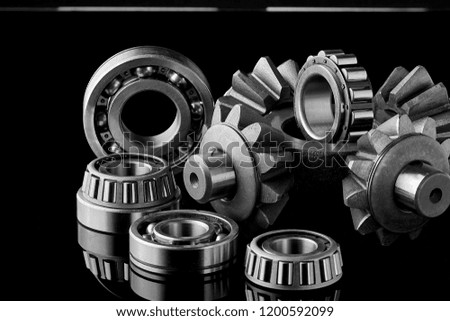 Gears, bearings and differential are on the table in the dark. Can be used as a background.