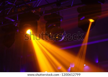 Disco ball and light projectors at night party light stream