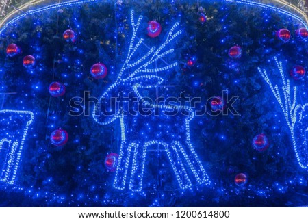 Decorative Christmas deer on a festive xmas tree and garland background