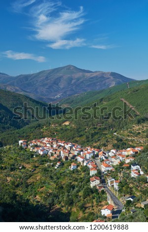 Group of houses together in a mountain village divided by a road in the Serra da Estrela. Sunny day. Cabeça, Portugal