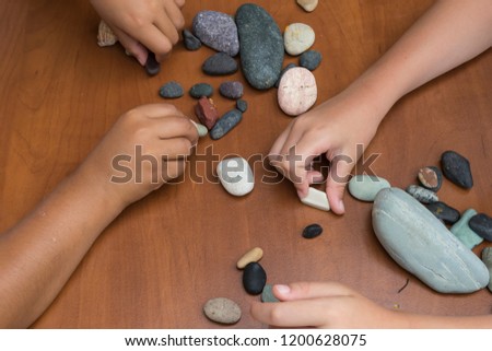 The child is playing with stones from children’s activities.kid draws something for her handcraft picture for nursery or kindergarten activity concept time.