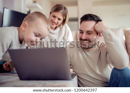 Happy family watching cartoon on laptop.