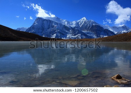 A clear picture of the high altitude Ice Lake along the Annapurna Circuit Trek near Manang in Nepal, Asia. The snowy peaks of the mighty Annapurnas in the himalaya can be seen in the background.