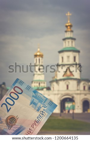 Russian money 2000 thousand rubles on the background of the Orthodox Church. Toned image, copy space. Blurred, soft focus