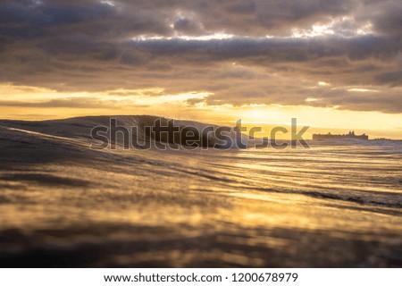 A breaking wave at sunset viewed from the water on Long Island, New York