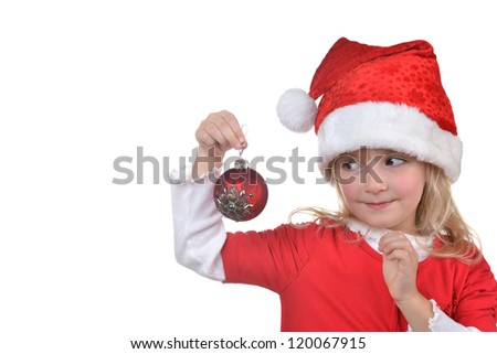  child in santa hat holding christmas decorations in hand