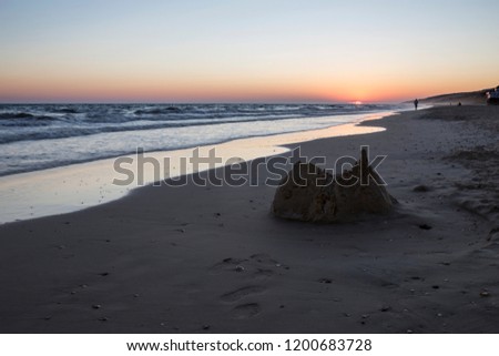 Collapsed sand castle at
Matalacanas beach during the magnificent sunrise. Costa de la Luz, Spain