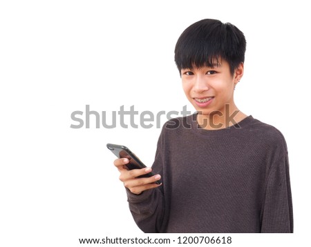 Portrait of Asian Teenage boy with mobile phone And brown sweater on white background. In the concept of technology and communication.