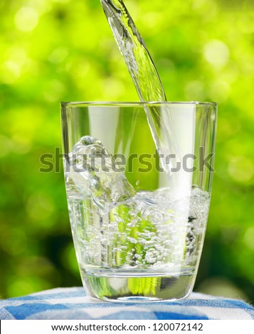 Glass of water on nature background. Royalty-Free Stock Photo #120072142