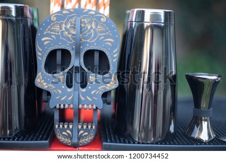 Cocktail equipment with skull straw holder on a bar
