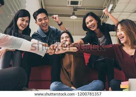 Young successful businesspeople are fist bumping after working hard at new project Royalty-Free Stock Photo #1200781357