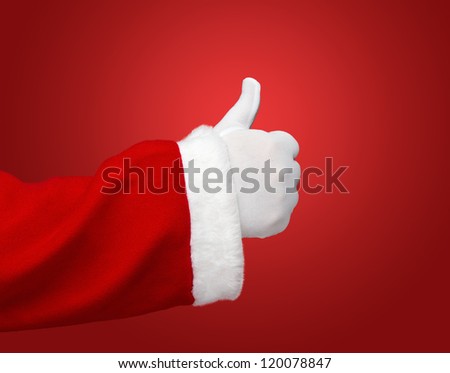 Santa Claus hand showing thumbs up over red background with copy space