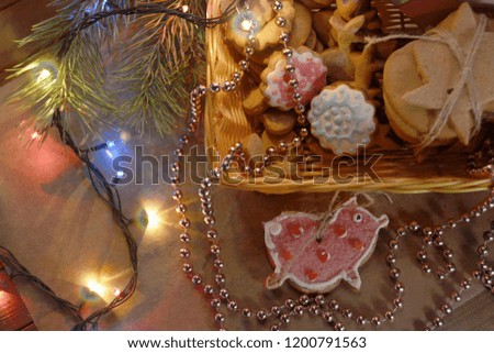 New Year's or Christmas still life with homemade gingerbread in a basket in the form of a pink pig, the symbol of the year. on the background of Christmas trees and garlands. 