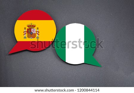 Spain and Nigeria flags with two speech bubbles on dark gray background