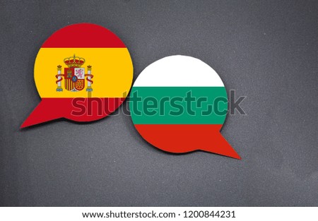 Spain and Bulgaria flags with two speech bubbles on dark gray background