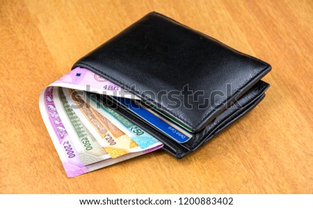 Indian Currency and a purse. Royalty-Free Stock Photo #1200883402