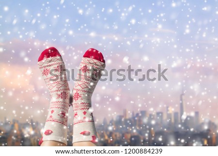 Women's feet in Christmas socks on the Manhattan background. New York city.  Winter concept.