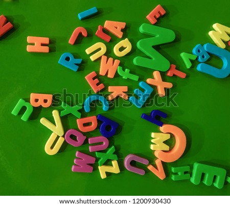 Colorful alphabet magnets on a green board.